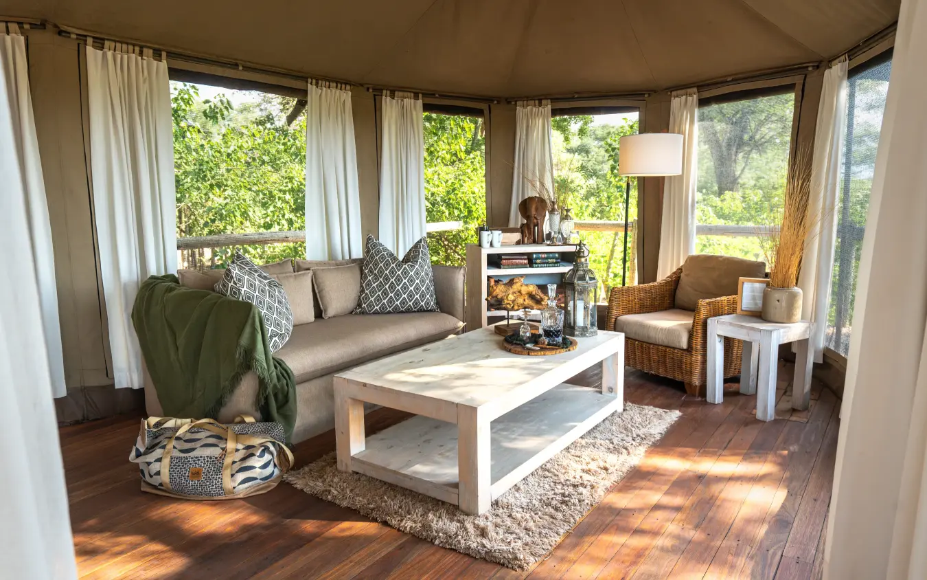 Luxury safari lodge interior with curved windows overlooking woodland, Nambwa Tented Lodge, Zambezi Region, Namibia