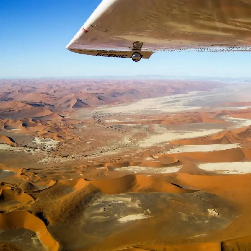 Desert landscape with sand dunes and sparse vegetation from aircraft, Swakopmund, Namibia