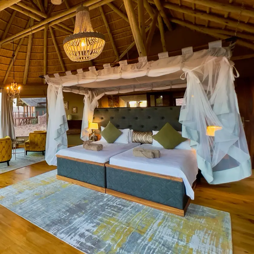Luxury safari suite with canopy bed and savanna views from wooden pavilion, Namib Outpost, Sossusvlei, Namibia
