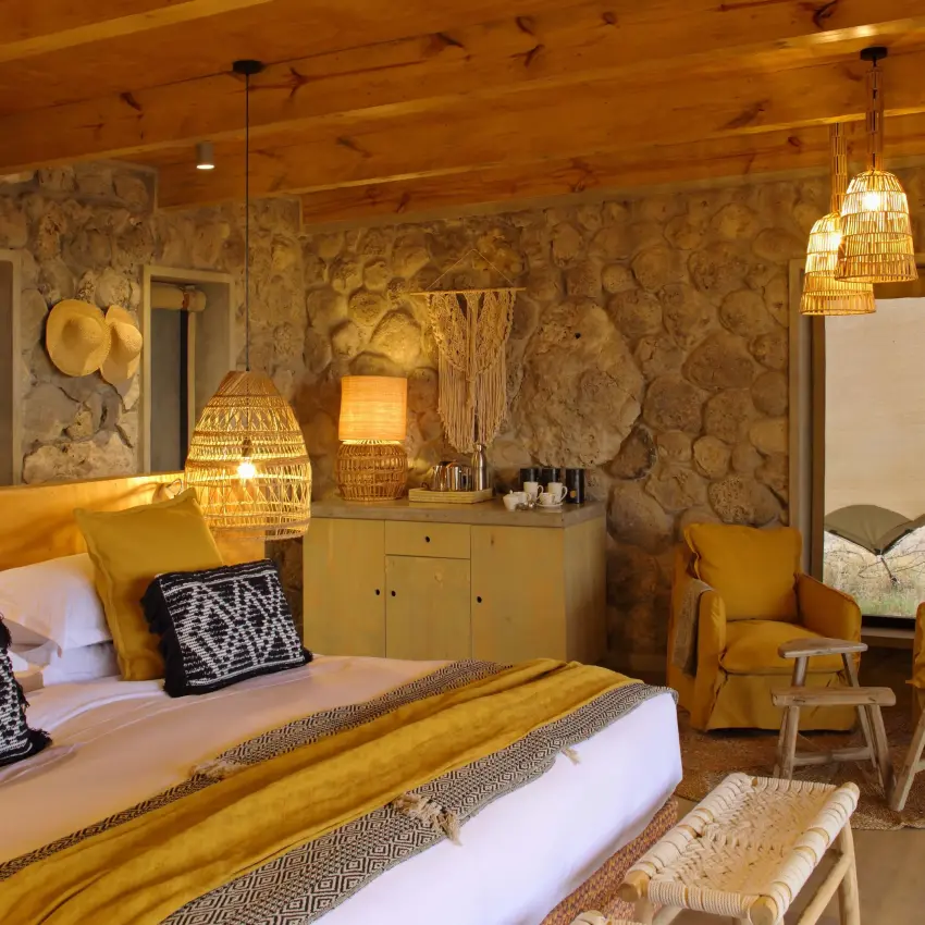 Luxury bedroom with gold accents and patterned wallpaper, Namiri Plains, Serengeti National Park, Tanzania