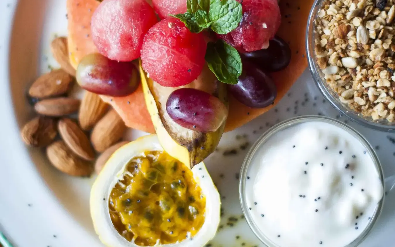 Breakfast plate with fresh grapes, passion fruit, almonds, and yogurt, Ndutu Safari Lodge, Serengeti National Park, Tanzania