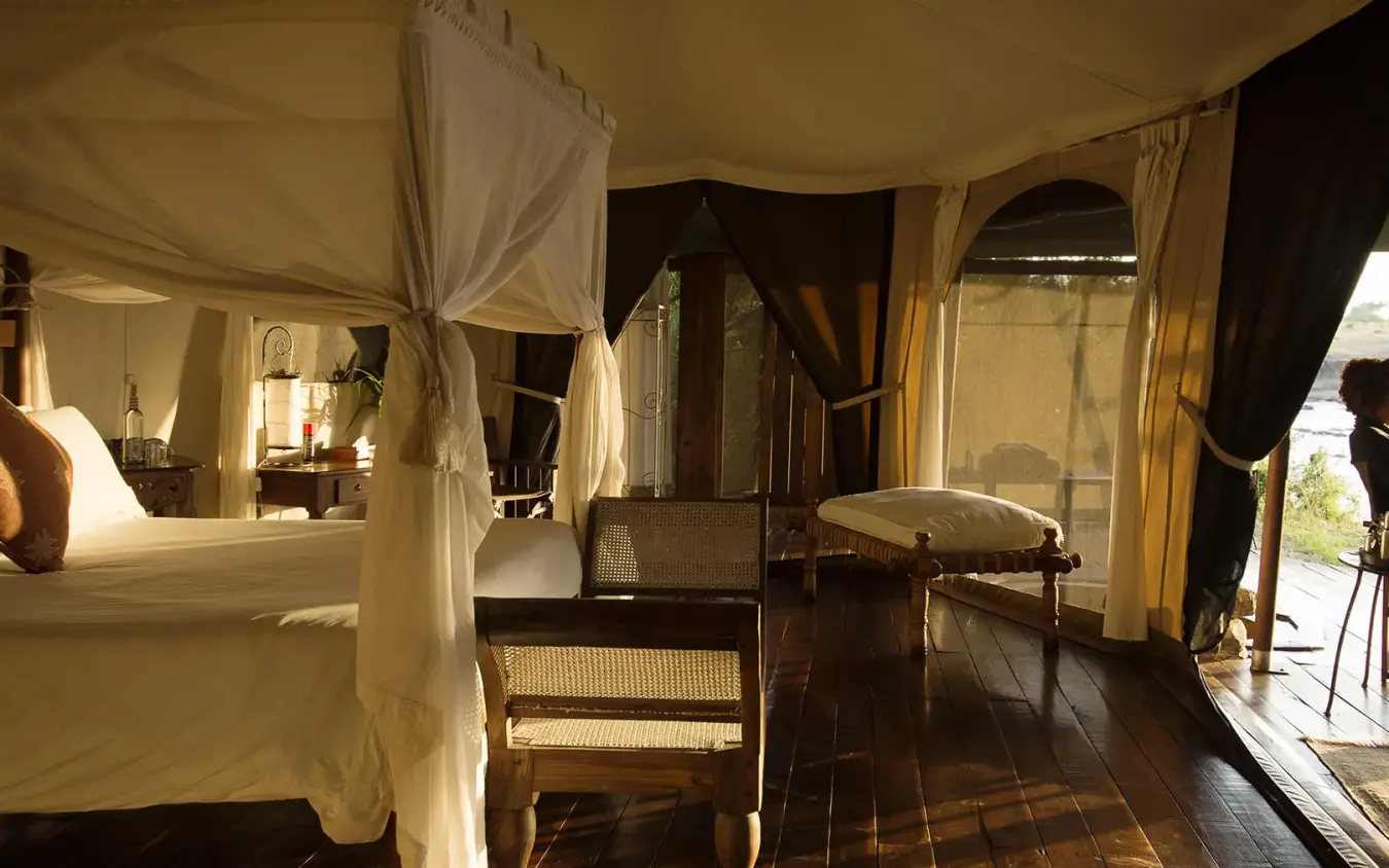 Luxury tent bedroom with river view and outdoor seating area, Ngare Serian, Maasai Mara, Kenya