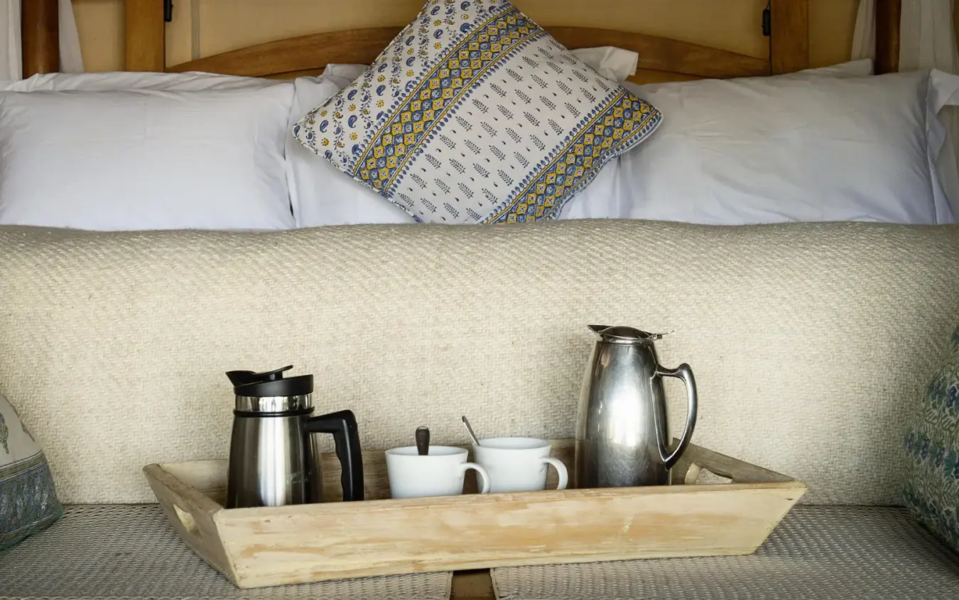 Bedroom interior with four-poster bed and morning beverage setup, Ngare Serian, Maasai Mara, Kenya