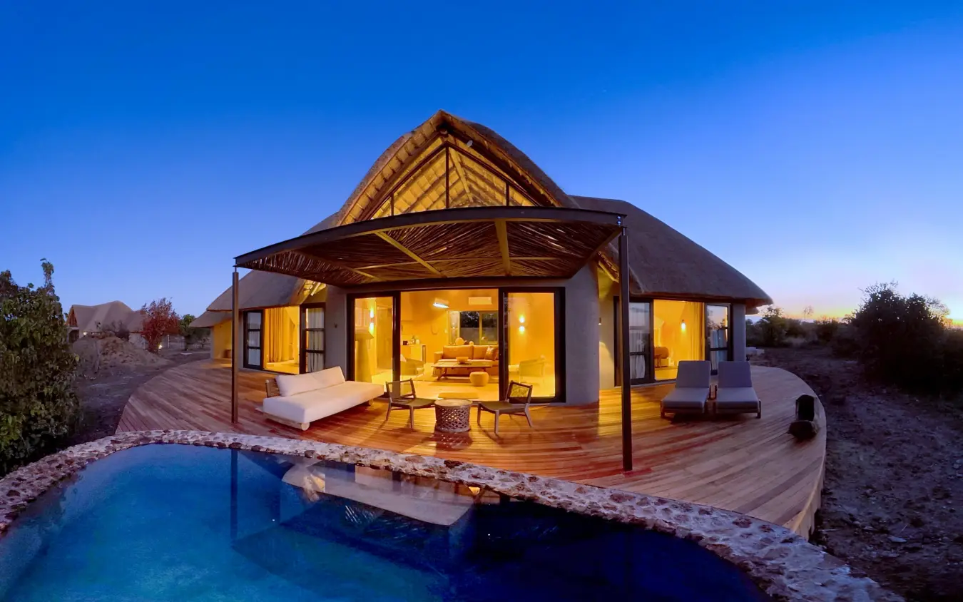 Luxury lodge with thatched roof and private pool at dusk, Ngoma Safari Lodge, Chobe, Botswana