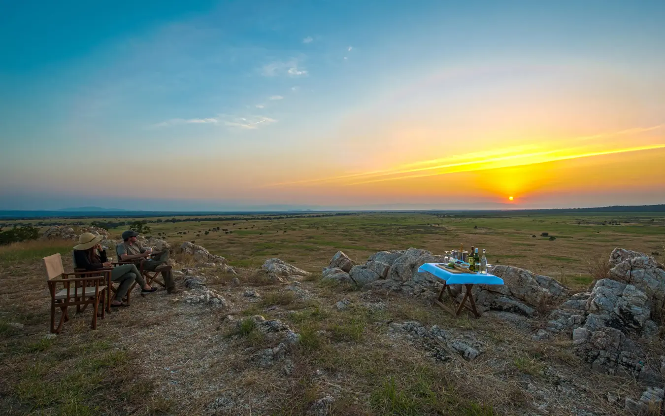 Guests dining at sunset overlooking vast plains, Nimali Tarangire, Tarangire National Park, Tanzania
