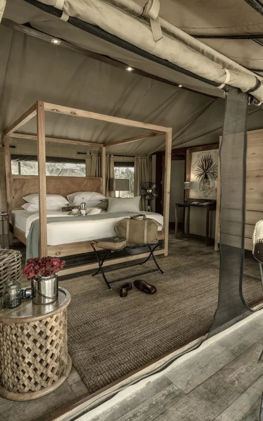 Luxury safari tent bedroom with four-poster bed and seating area, Nimali Tarangire, Tarangire National Park, Tanzania
