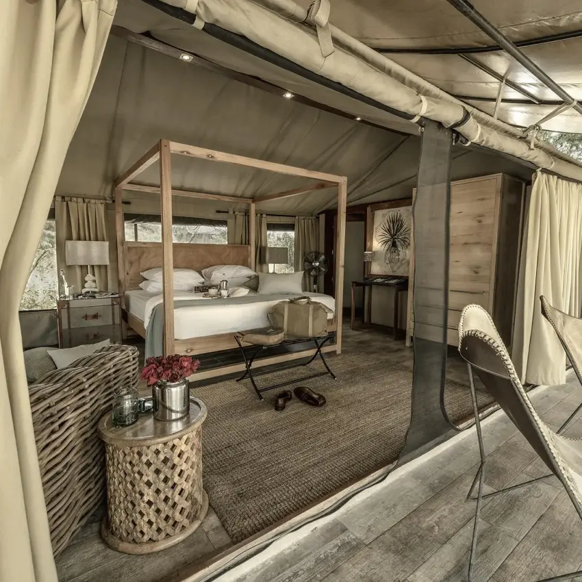 Luxury safari tent bedroom with four-poster bed and seating area, Nimali Tarangire, Tarangire National Park, Tanzania
