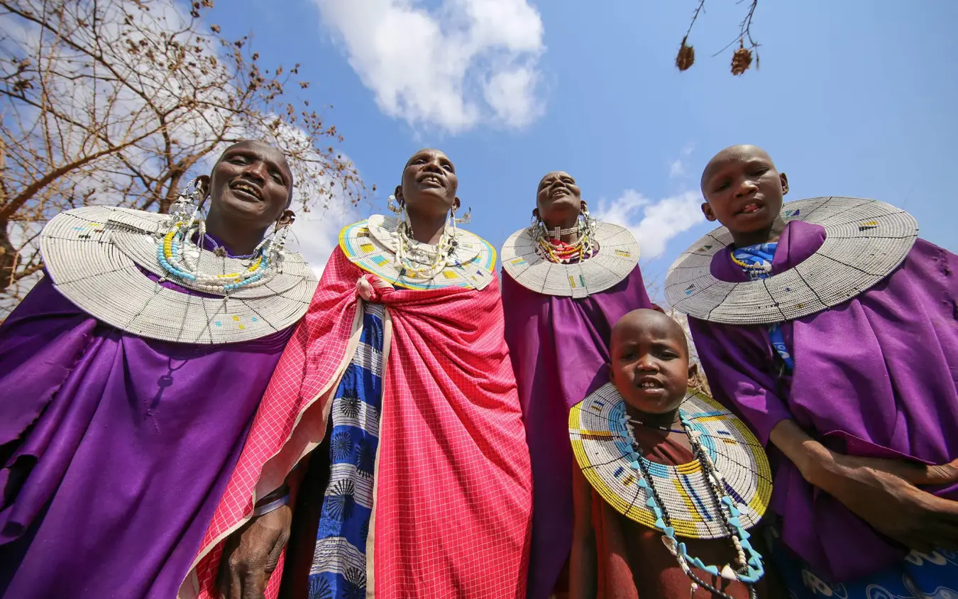 Local community members in traditional purple dress and beaded jewelry, Nimali Tarangire, Tarangire National Park, Tanzania