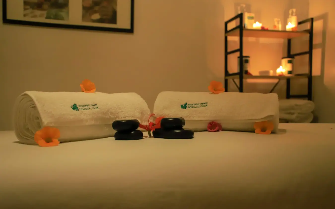 Rolled towels and black stones spa arrangement with flowers, Nkuringo Gorilla Lodge, Bwindi Impenetrable Forest, Uganda