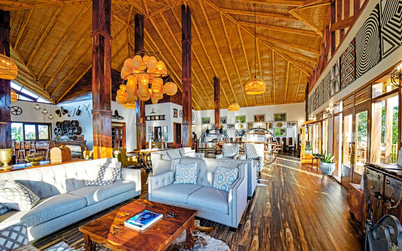Open-plan lounge with wooden beams and blue seating, Nkuringo Gorilla Lodge, Bwindi Impenetrable Forest, Uganda