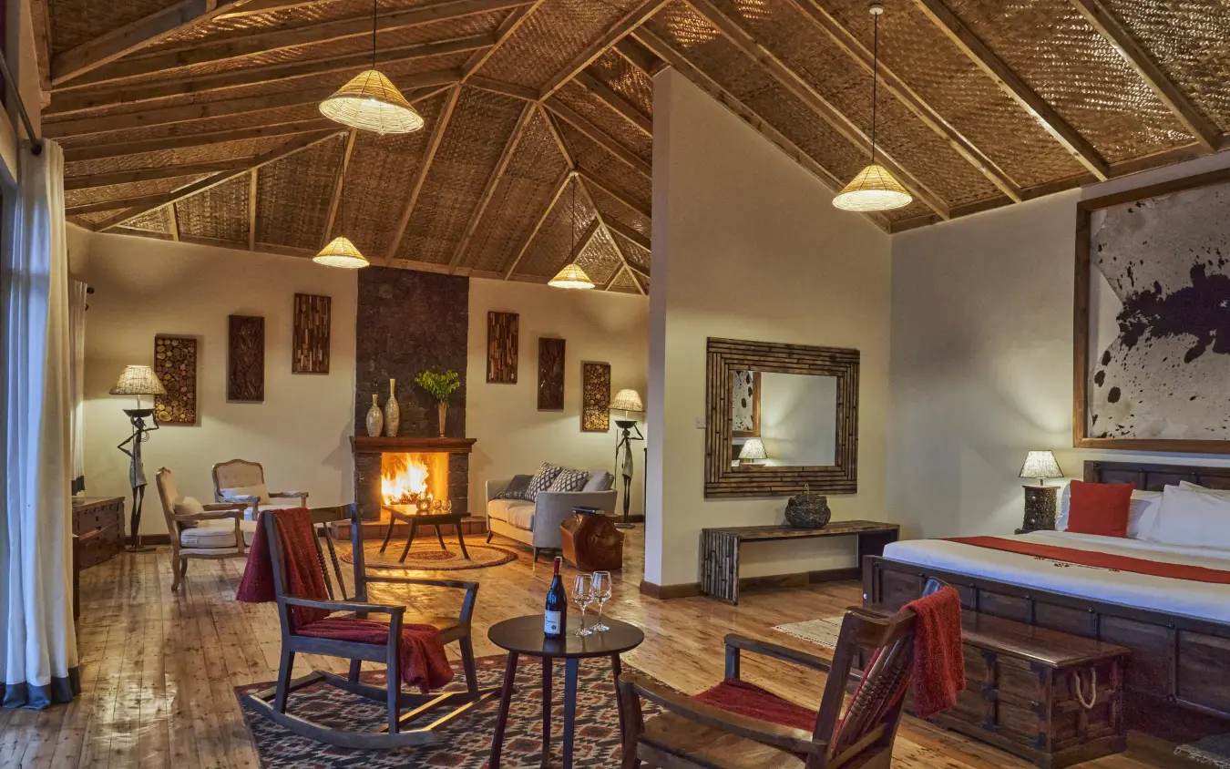 Spacious lodge interior with fireplace and comfortable seating, Nkuringo Gorilla Lodge, Bwindi Impenetrable Forest, Uganda