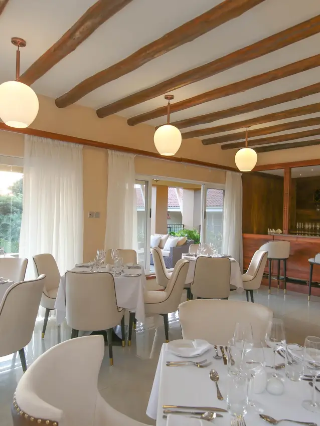 Fine dining restaurant interior with set tables and bar area, No.5 Boutique Hotel, Entebbe and Kampala, Uganda