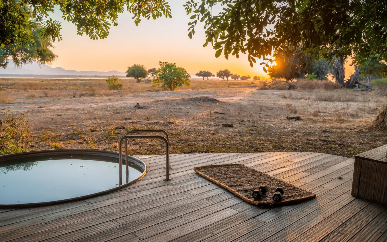 Wooden deck with plunge pool overlooking savanna at sunset, Nyamatusi Camp, Mana Pools, Zimbabwe