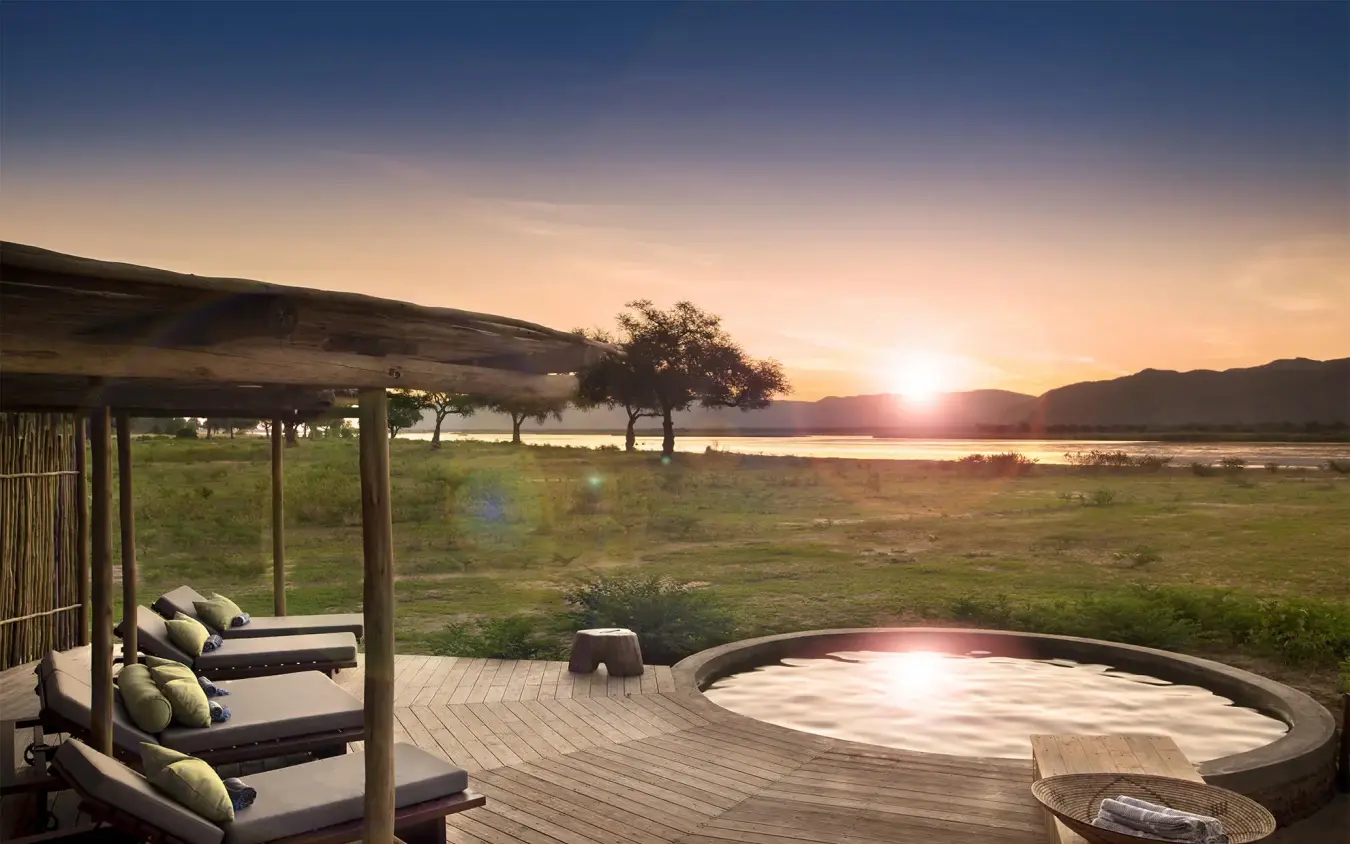 Wooden deck with hot tub overlooking river at sunset, Nyamatusi Camp, Mana Pools, Zimbabwe