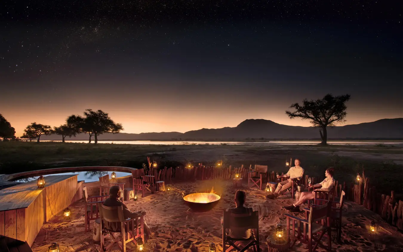Evening gathering around fire pit with lake view, Nyamatusi Camp, Mana Pools, Zimbabwe