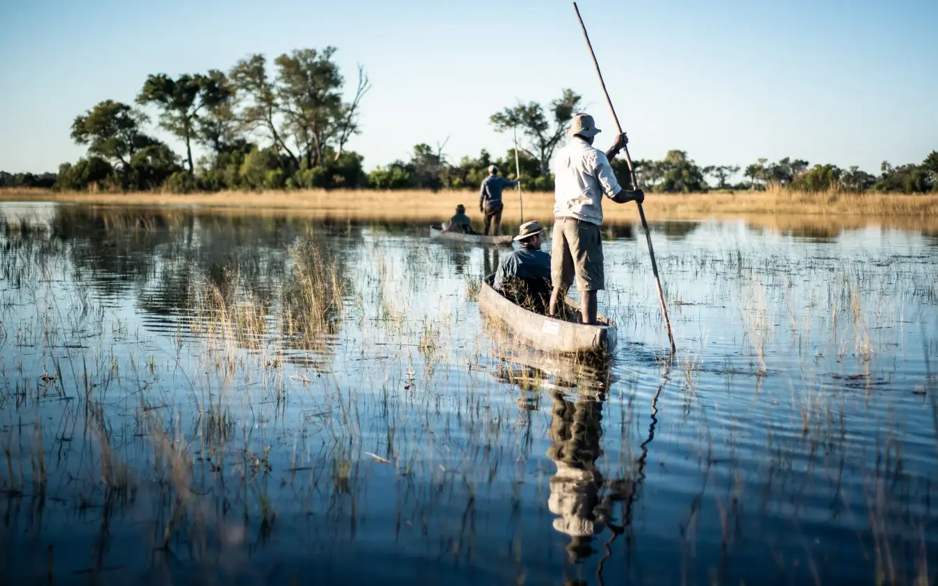 Tourists poling traditional boat through shallow water channels