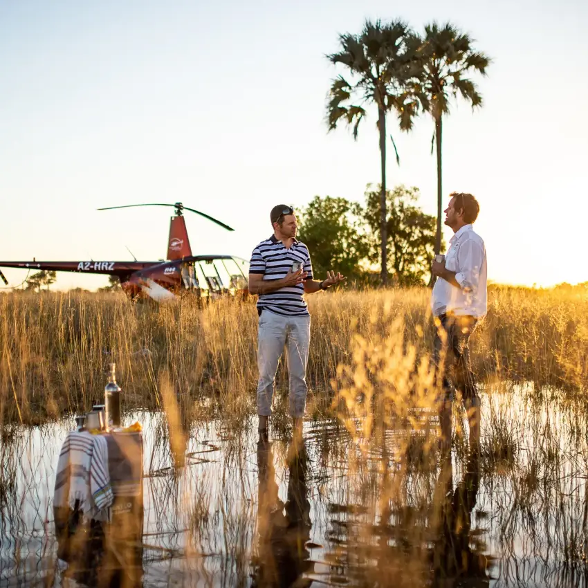 Helicopter tour group standing in shallow wetland water