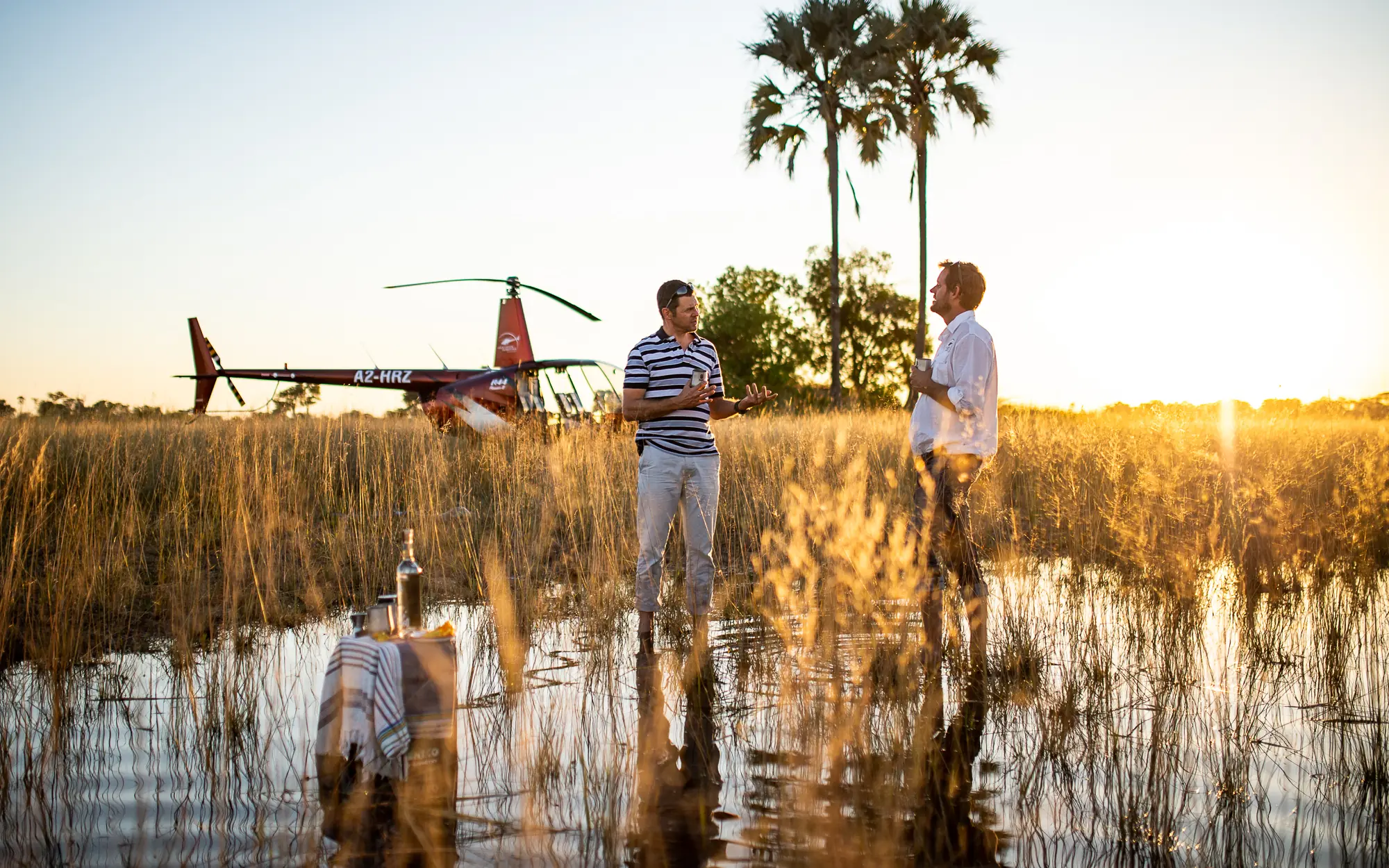 Helicopter tour group standing in shallow wetland water