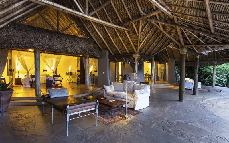 Open-air lounge with thatch roof and glowing interiors, Ol Donyo Lodge, Amboseli and Chyulu Hills, Kenya