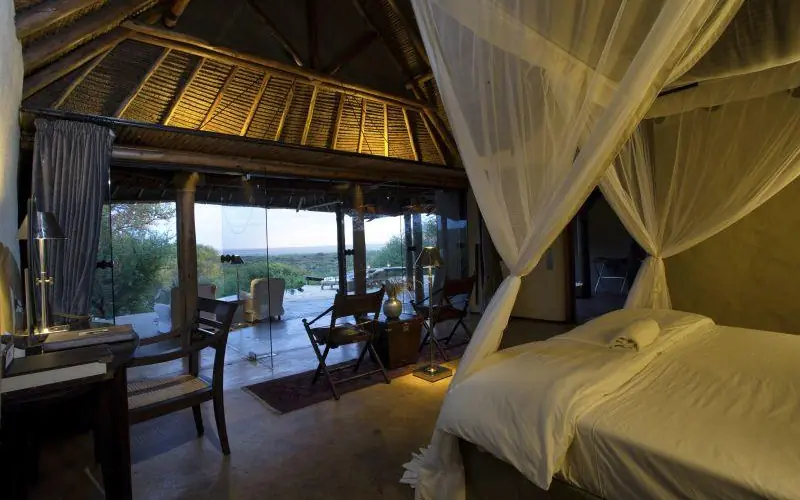 Luxury bedroom with sheer canopy and expansive landscape views, Ol Donyo Lodge, Amboseli and Chyulu Hills, Kenya