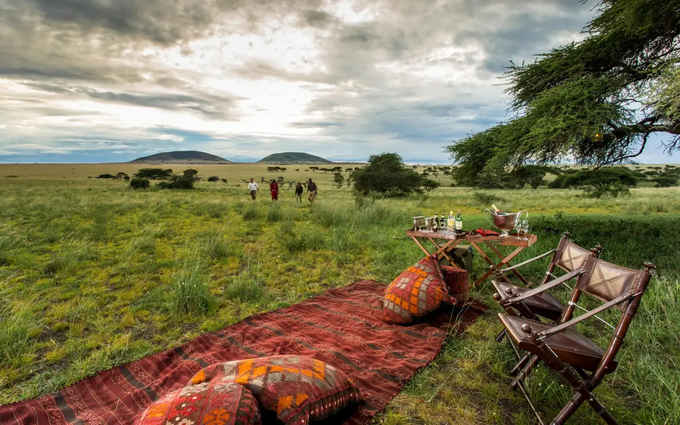Safari picnic setup with chairs and blankets on grassland, Ol Donyo Lodge, Amboseli and Chyulu Hills, Kenya