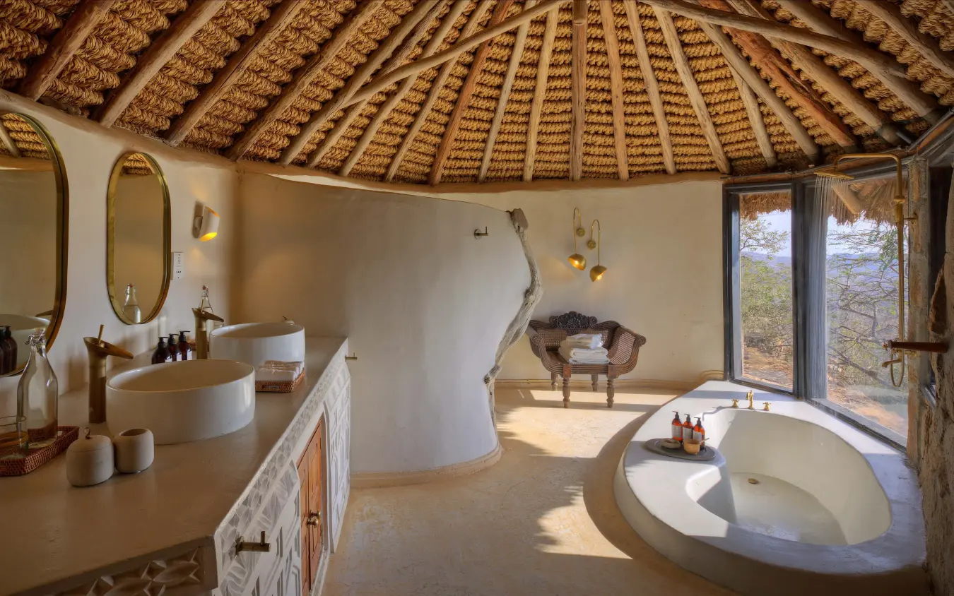 Luxury safari lodge bathroom with sunken tub and thatched roof interior, Ol Lentille, Laikipia Highlands, Kenya