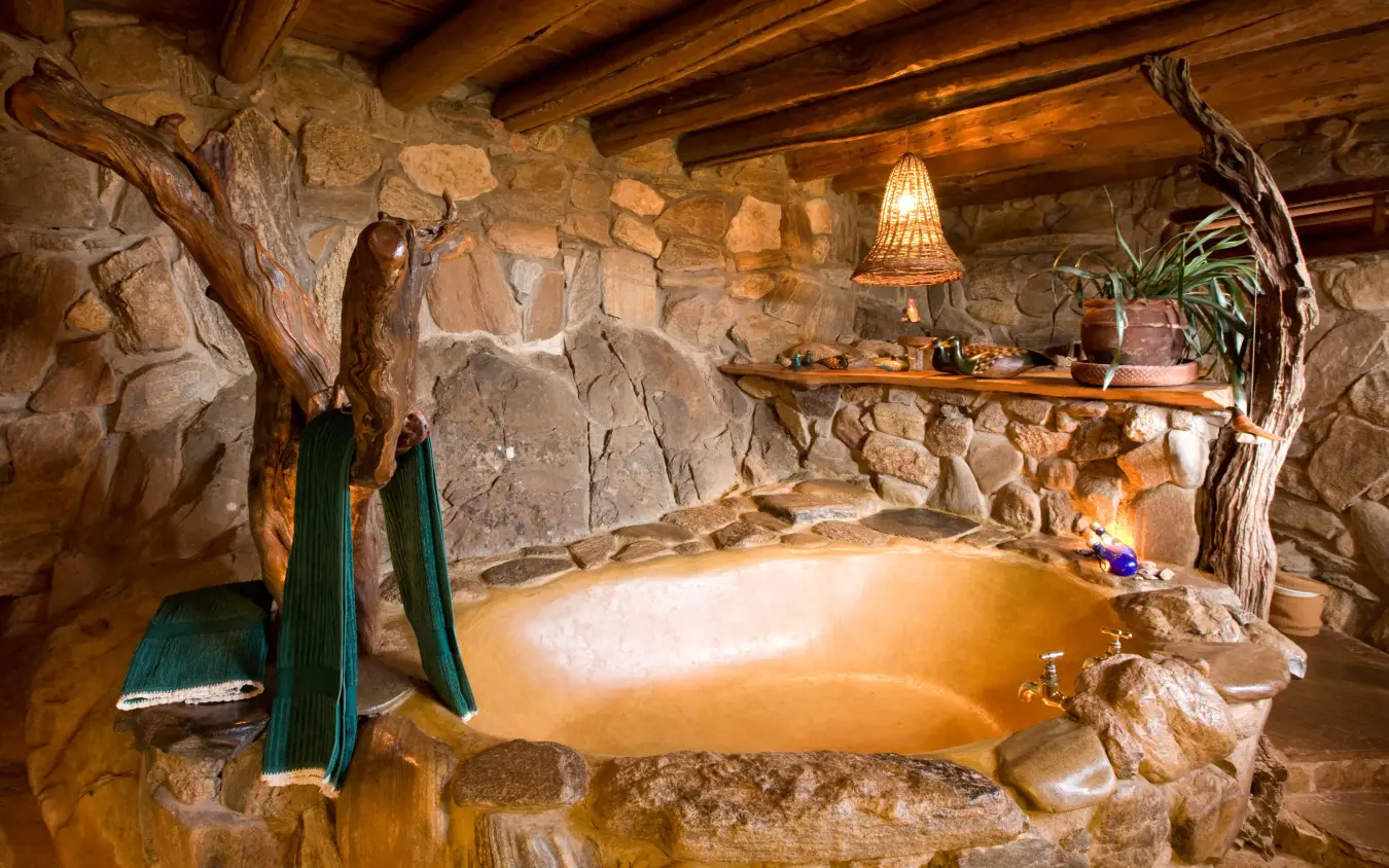Stone-walled bathroom with natural mineral bath and wooden beams, Ol Malo Lodge, Laikipia Highlands, Kenya
