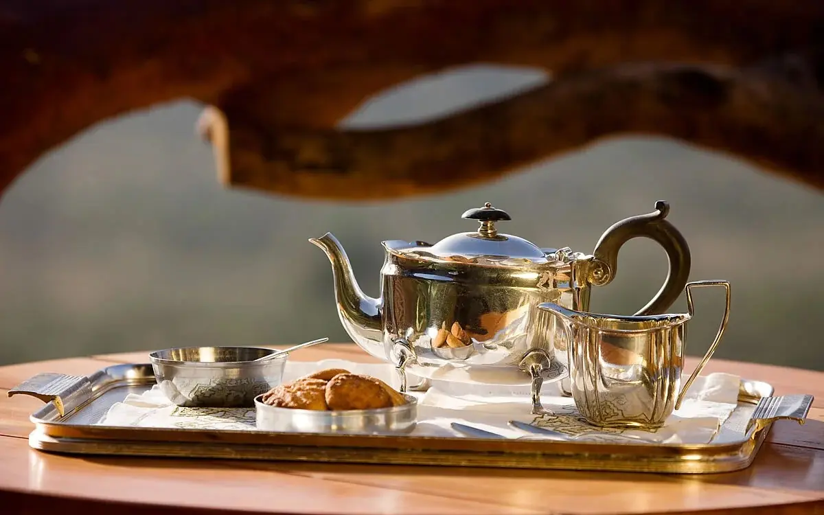 Silver tea service with pastry on wooden table, Ol Malo Lodge, Laikipia Highlands, Kenya