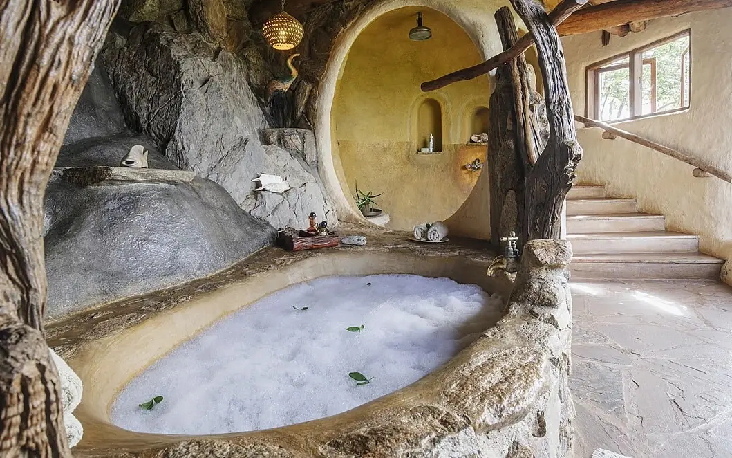 Natural stone bathroom with sunken tub and shower, Ol Malo Lodge, Laikipia Highlands, Kenya