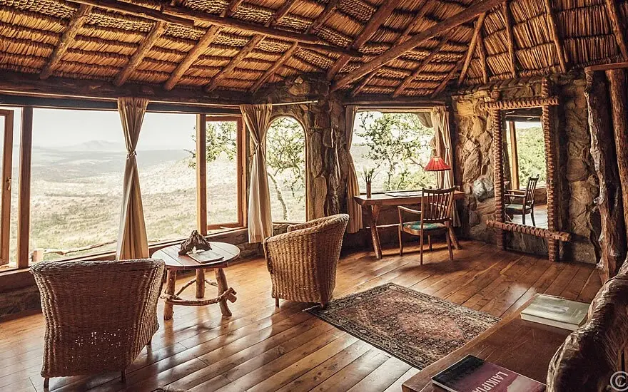 Interior lounge with expansive windows overlooking savanna landscape, Ol Malo Lodge, Laikipia Highlands, Kenya