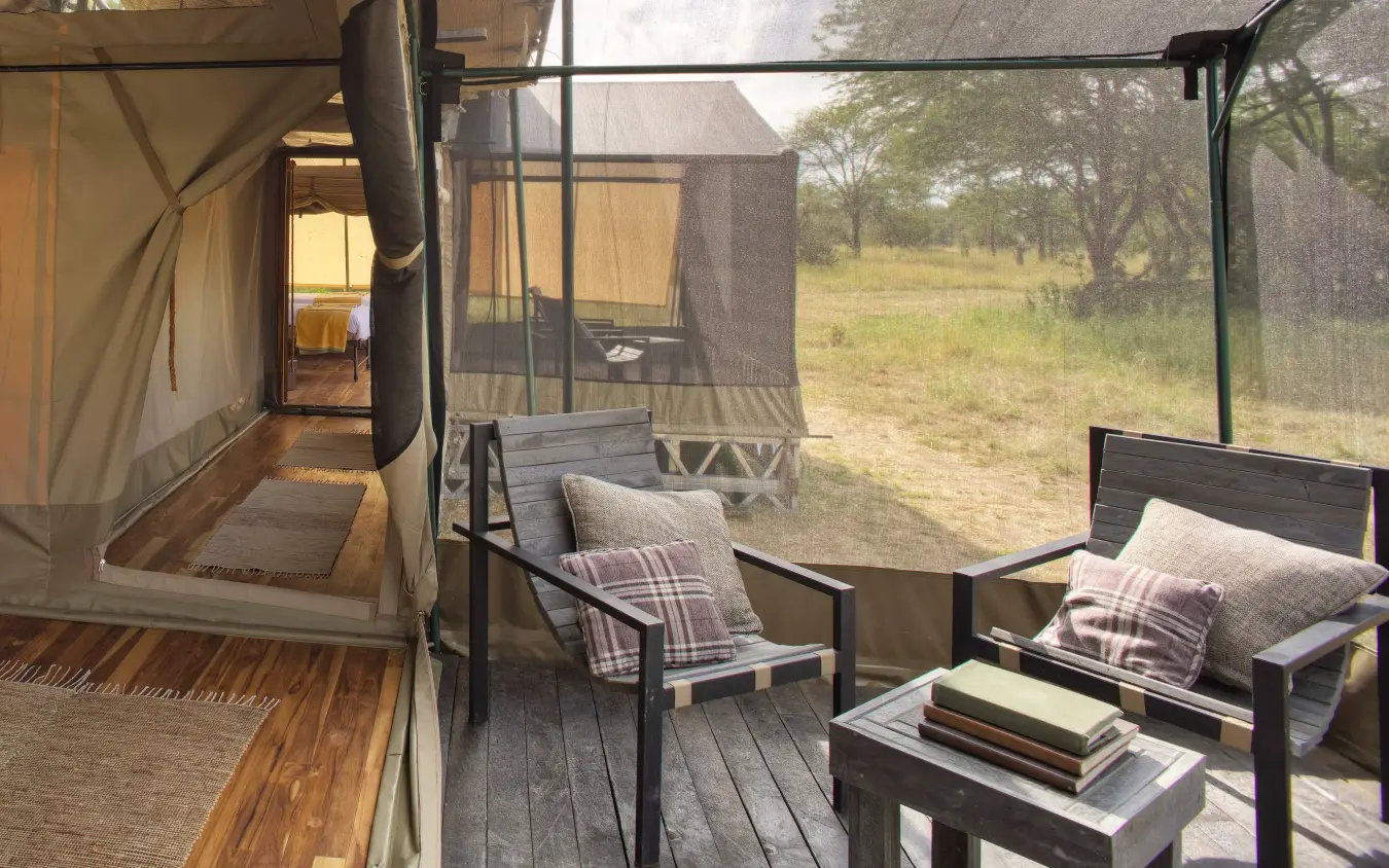 Safari tent deck with chairs overlooking savanna landscape, Olakira Migration Camp, Serengeti National Park, Tanzania