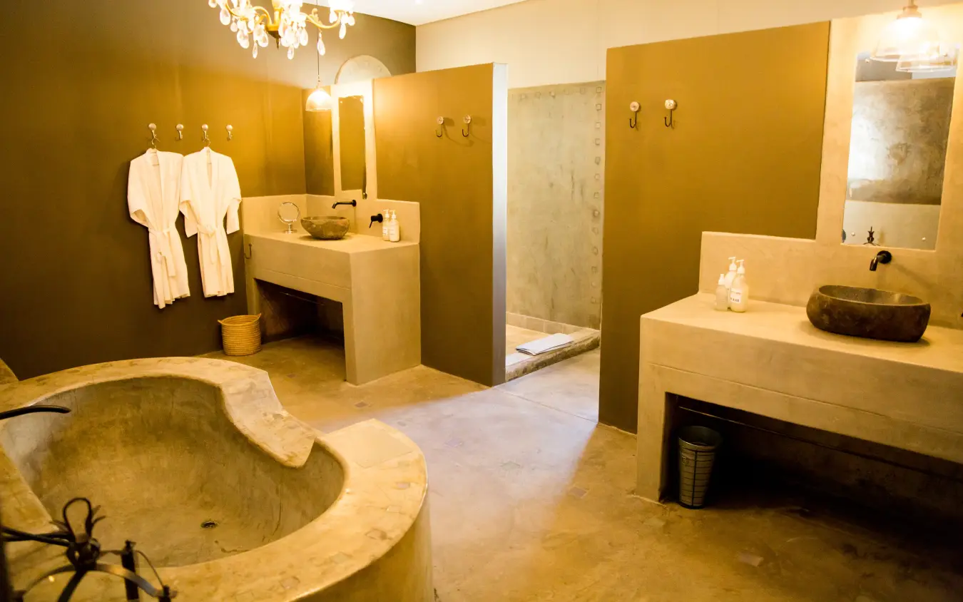 Luxury spa bathroom with stone bathtub and dual vanities in earthy tones, Olive Grove Guesthouse, Windhoek, Namibia