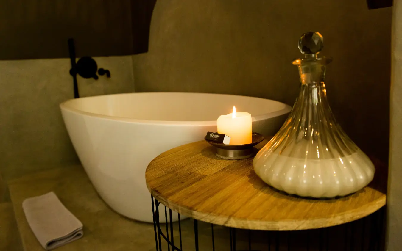 Luxury bathroom with freestanding bathtub, candlelit side table and decorative glass decanter, Olive Grove Guesthouse, Windhoek, Namibia