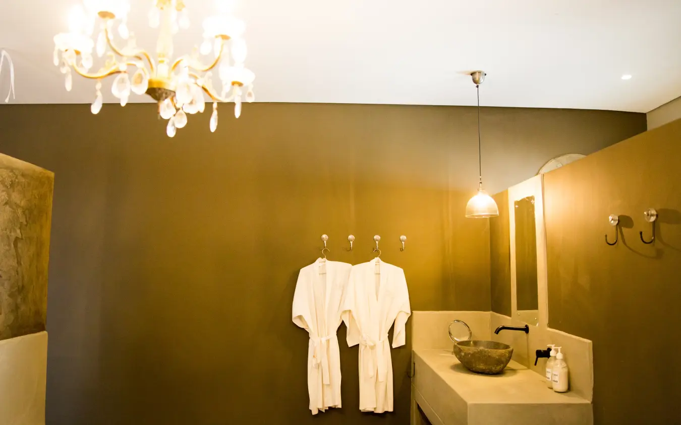 Luxurious bathroom with golden walls and crystal chandelier, Olive Grove Guesthouse, Windhoek, Namibia
