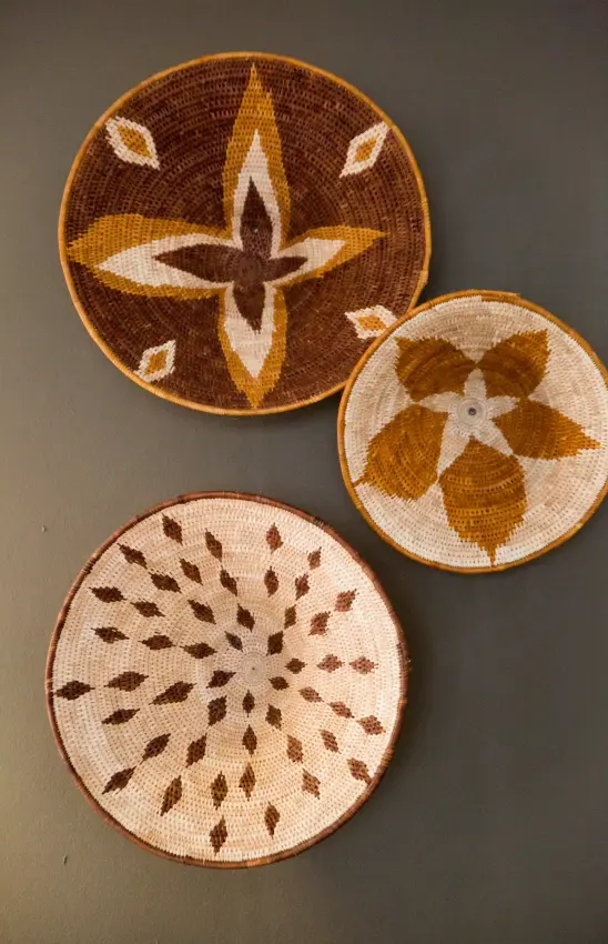 Woven baskets with traditional geometric patterns displayed on wall, Olive Grove Guesthouse, Windhoek, Namibia