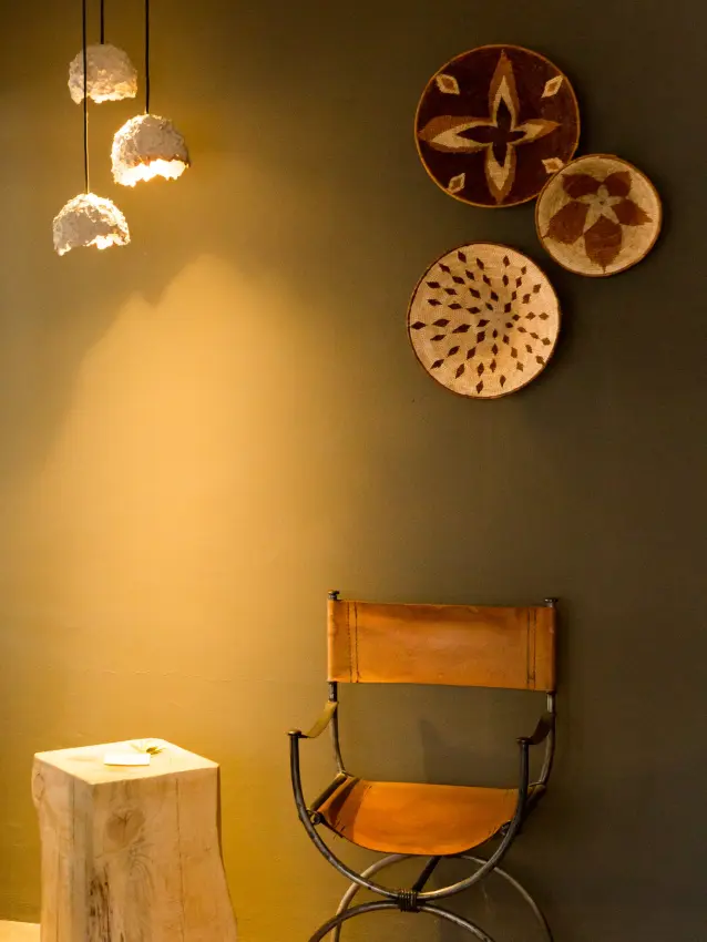 Minimalist interior wall with woven circular wall hangings and wooden bench, Olive Grove Guesthouse, Windhoek, Namibia