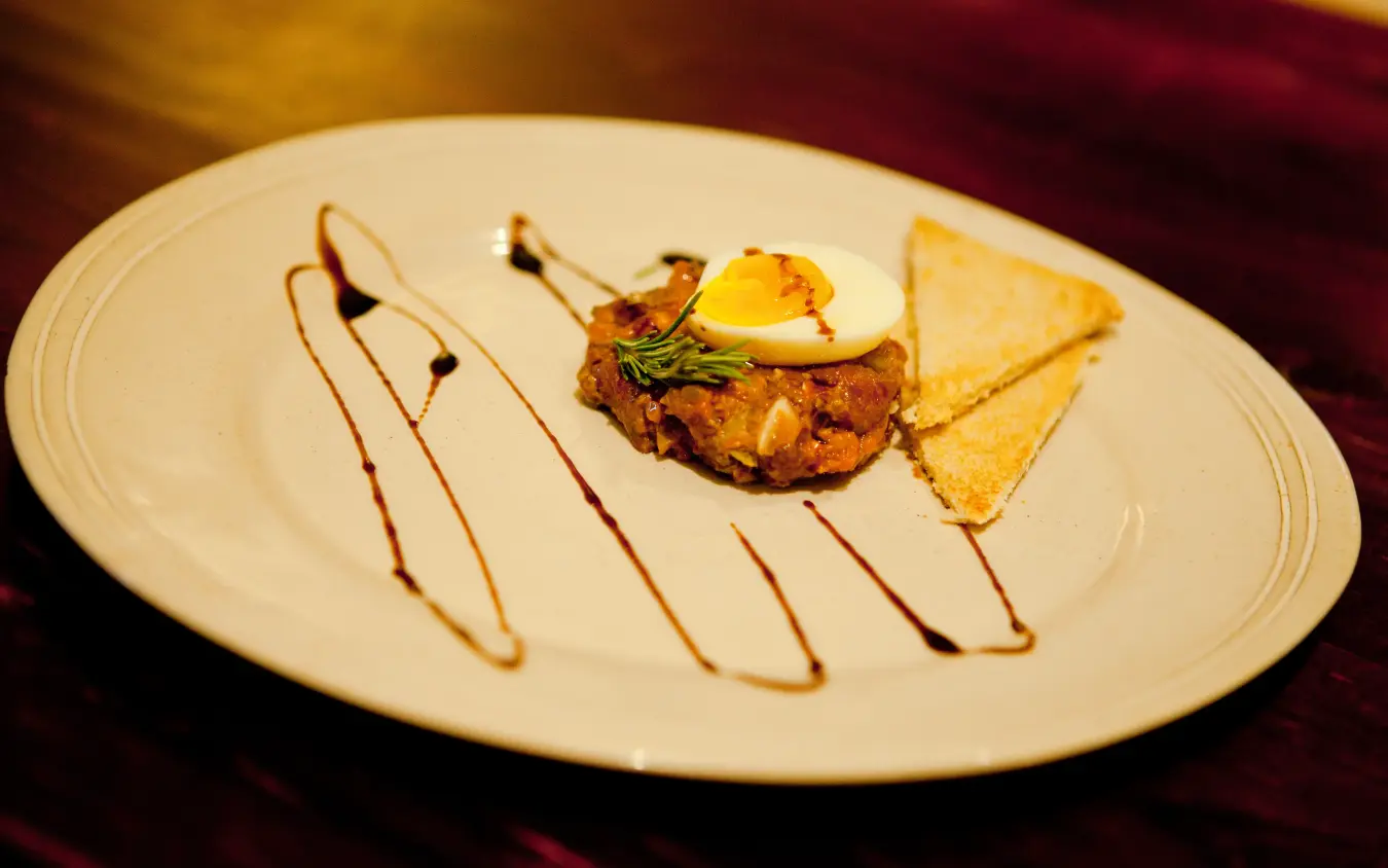 Plated appetizer with seared meat, crispy toast triangle and sauce drizzle, Olive Grove Guesthouse, Windhoek, Namibia