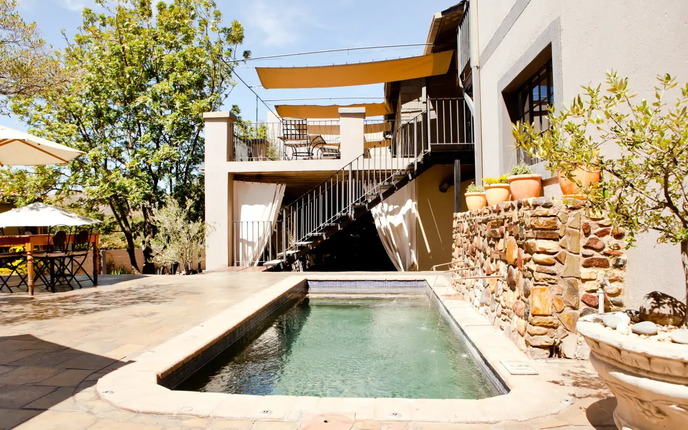 Contemporary lodge with infinity pool and multi-level wooden deck architecture, Olive Grove Guesthouse, Windhoek, Namibia
