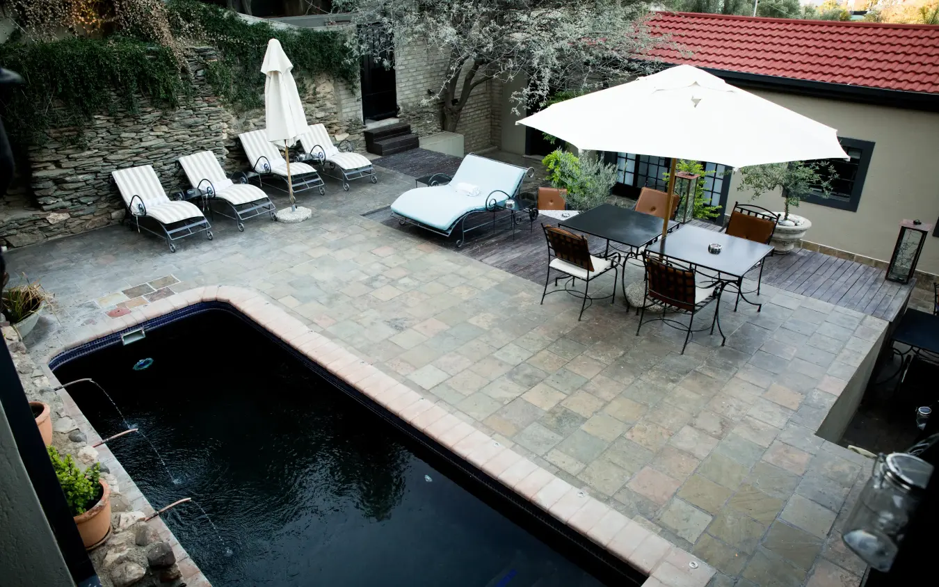 Luxury courtyard with swimming pool and shaded dining terrace, Olive Grove Guesthouse, Windhoek, Namibia