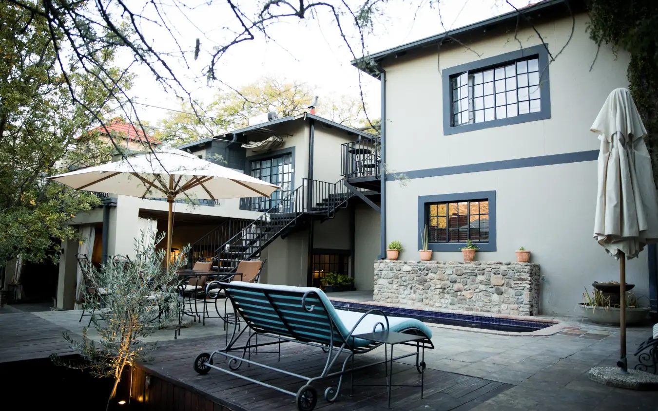 Courtyard with lounge chairs, umbrella and modern residential architecture, Olive Grove Guesthouse, Windhoek, Namibia