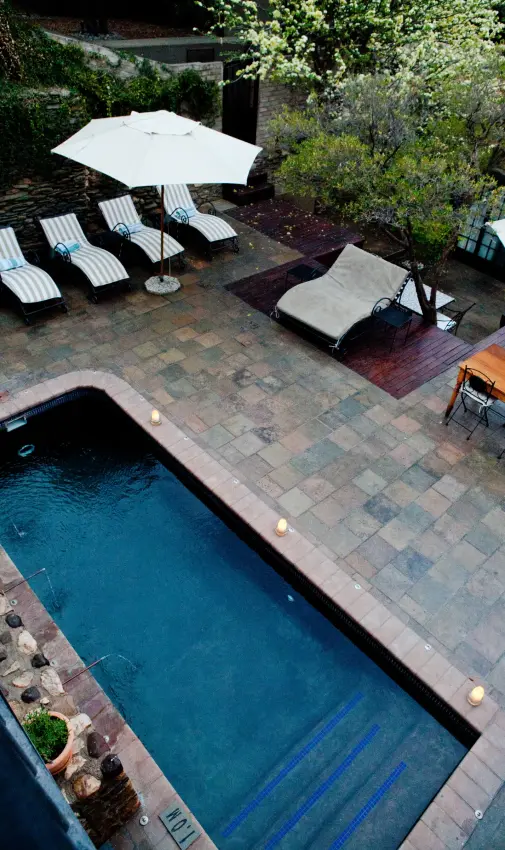 Luxury lap pool with lane markers beside paved terrace at dusk, Olive Grove Guesthouse, Windhoek, Namibia
