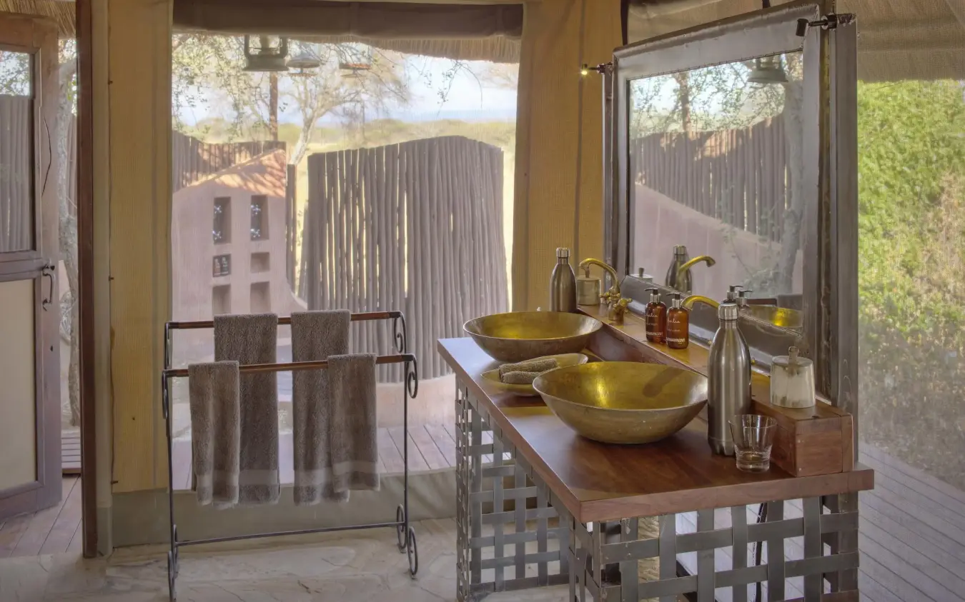 Outdoor bathroom with dual brass sinks and canvas roof, Oliver’s Camp, Tarangire National Park, Tanzania