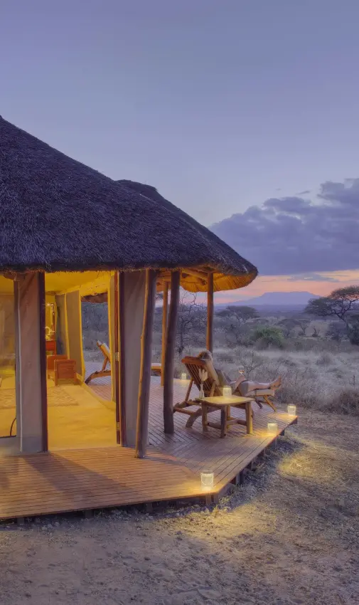 Thatched safari lodge at dusk with savanna landscape, Oliver’s Camp, Tarangire National Park, Tanzania