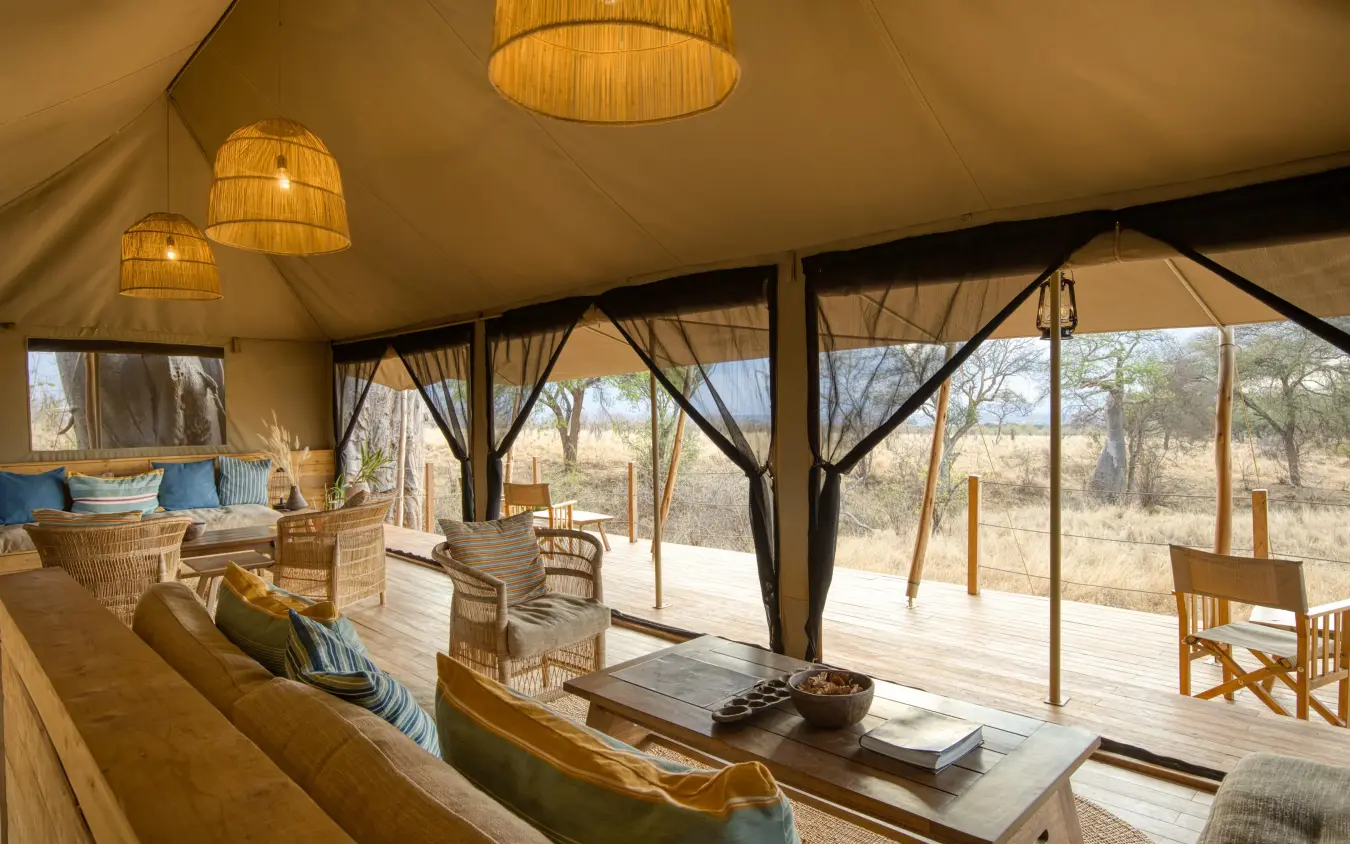 Luxury safari tent interior with panoramic savanna views through floor-to-ceiling windows, Olkeri Camp, Tarangire National Park, Tanzania
