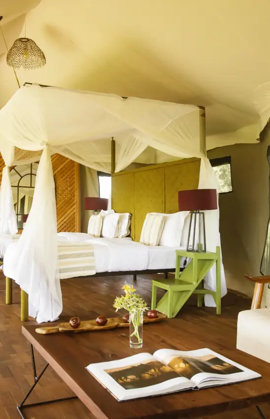 Spacious safari tent bedroom with four-poster bed and seating, Olmara Camp, Serengeti National Park, Tanzania