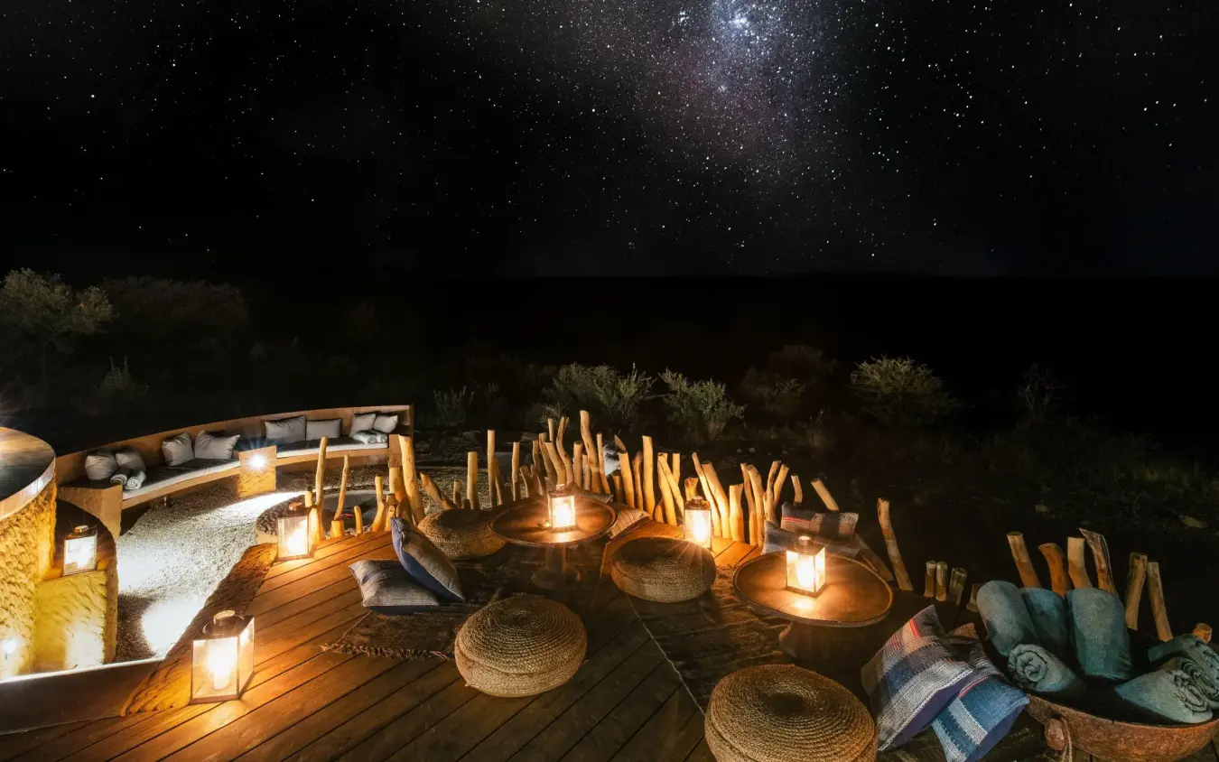 Night sky with Milky Way above illuminated outdoor deck, Omaanda, Windhoek, Namibia