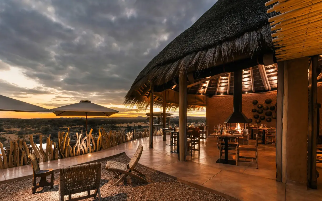 Thatched deck with sunset views over African savanna landscape, Omaanda, Windhoek, Namibia