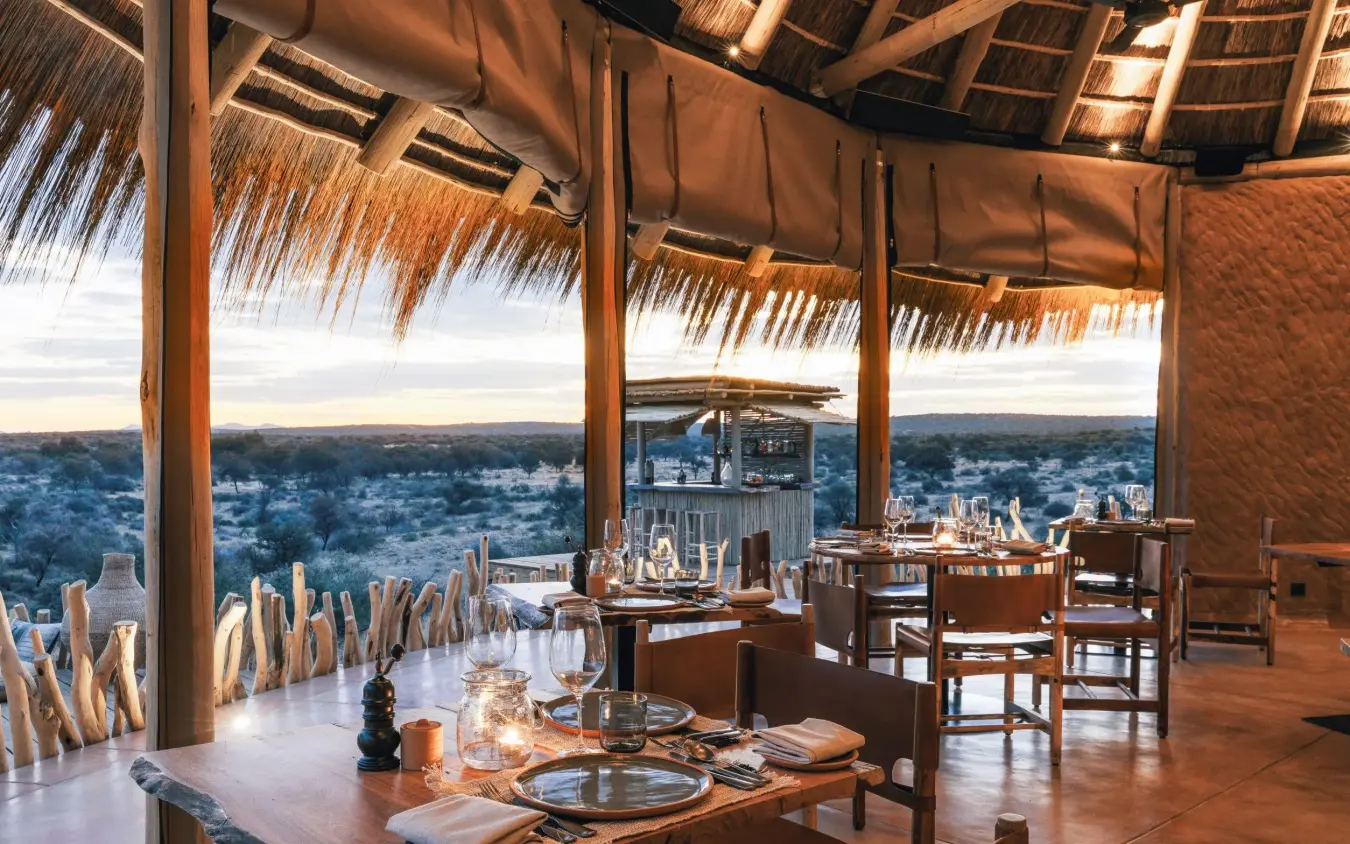 Dining area with table settings overlooking savanna landscape, Omaanda, Windhoek, Namibia