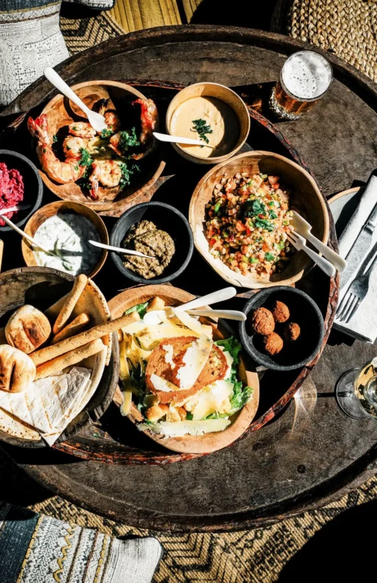 Overhead view of plated dishes and small bowls on dark table, Windhoek, Namibia