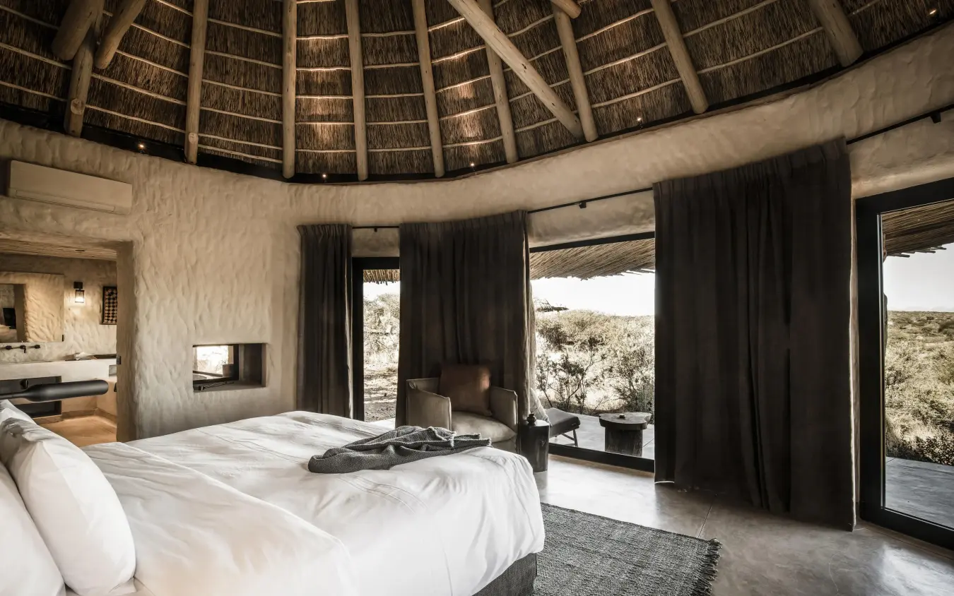 Circular bedroom with thatched roof and expansive landscape views, Omaanda, Windhoek, Namibia